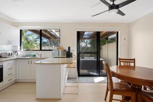 a kitchen with a table and a dining room at Hawks Nest Hideaway | Spa, BBQ, Bikes & Pool Table in Hawks Nest