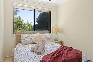 a bedroom with a bed with a large window at Hawks Nest Hideaway | Spa, BBQ, Bikes & Pool Table in Hawks Nest