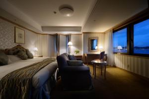 a hotel room with a bed and a chair and a window at Kamakura Park Hotel in Kamakura