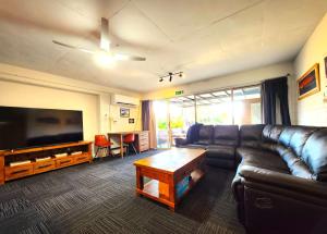 a living room with a couch and a large flat screen tv at Spacious Guest Room 7 Sleeps 5 Near Shops with Free Parking in Highett
