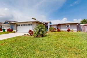 a large house with a garage and a grass yard at 620 S Easy St in Sebastian