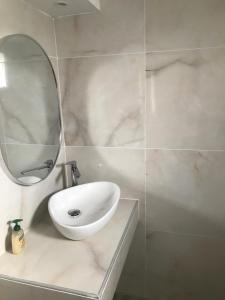 a bathroom with a white sink and a mirror at Maison de roche in Sozopoli