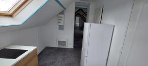 a kitchen with a white refrigerator and a window at Studio avec vu sur le Loir in La Flèche