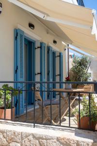 a balcony with blue shutters and a table at Casa Mary Aegina in Egina