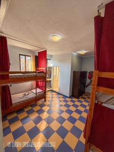 a room with two bunk beds and a checkered floor at The Galley Party Hostel in Shkodër