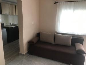 a couch in a living room with a window at Maison de roche in Sozopoli +12 photos