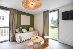 a bedroom with a bed and a table and a large window at Le Clos des Cadoles in Les Riceys +23 photos