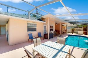 a patio with a table and chairs and a swimming pool at 1295 Barber St in Sebastian