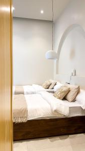 a large bed with white sheets and pillows on it at Cliff Chalet-Amrat in Al Amarat +8 photos