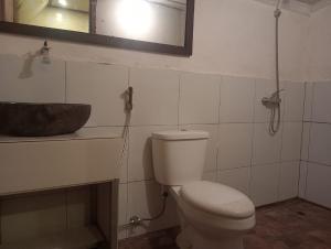 a bathroom with a toilet and a sink at Pondok sunset inn in Senaru