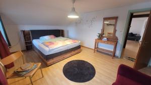 ein kleines Schlafzimmer mit einem Bett und einem Spiegel in der Unterkunft BnB Ilfis Wohnung Nr 1 in Langnau im Emmental