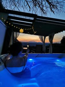 a person in a jacuzzi tub with a sunset at Messzikék in Egerszalók