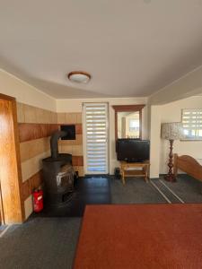 a living room with a stove and a television at Domek Trapera in Smyczyna