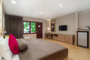a large bedroom with a large bed with red pillows at SENTIDO Khao Lak in Khao Lak