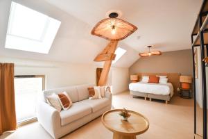 a living room with a couch and a bed at Le Clos des Cadoles in Les Riceys