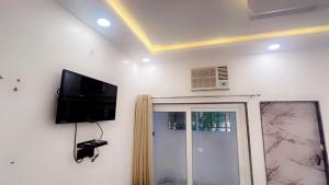 a room with a flat screen tv on a wall at SUNRISE Near Lucknow Airport in Lucknow
