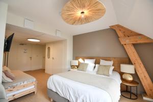 a bedroom with a large white bed and a staircase at Le Clos des Cadoles in Les Riceys