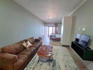 a living room with a couch and a coffee table at Waveside Guesthouse in Durban