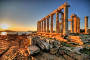 an ancient temple with columns on a beach at sunset at Beachfront Apprtment on Athens Riviera in Saronida