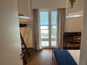 a bedroom with a bed and a desk and a window at Beachfront Apprtment on Athens Riviera in Saronida +16 photos