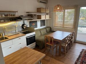 a kitchen and living room with a table and a couch at Beachfront Apprtment on Athens Riviera in Saronida