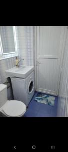 a white bathroom with a toilet and a sink at Apartment on Melashvili 24 (Old Batumi) in Batumi +28 photos