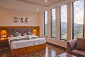 a bedroom with a bed and a couch and windows at Hardys Retreat in Mai Jūbar