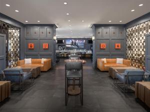 a restaurant with couches and tables and a tv at Hilton Dallas-Park Cities in Dallas