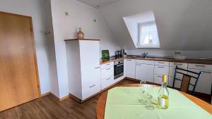 a kitchen with a table with a bottle of wine on it at Ferienapartment Weber-Loskill in Mehring