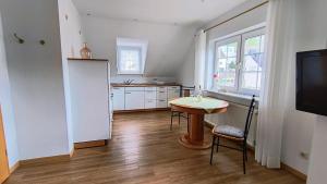 a kitchen with a table and a white refrigerator at Ferienapartment Weber-Loskill in Mehring