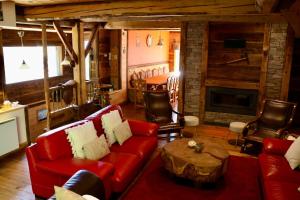 a living room with a red couch and a table at Authentic chalet in Saint-Jean-dʼArves