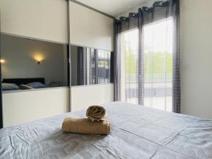 a bedroom with a bed with a towel on it at Les TERRASSES DE LAYOULE in Rodez