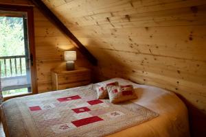 a bedroom with a bed in a log cabin at Authentic chalet in Saint-Jean-dʼArves