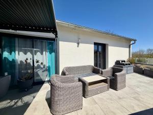 a patio with two wicker chairs and a table at Les TERRASSES DE LAYOULE in Rodez