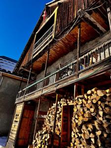 a wooden building with a balcony and a pile of wood at Authentic chalet in Saint-Jean-dʼArves