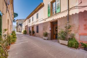 an empty street in an old town with plants at Ideal Property Mallorca - Corro Sant Jaume in Alcudia