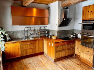 a kitchen with wooden cabinets and stainless steel appliances at Authentic chalet in Saint-Jean-dʼArves