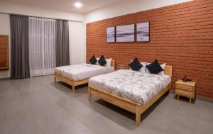 two beds in a room with a brick wall at Atmosfera Bengaluru, India in Bangalore +73 photos