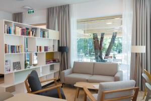 a living room with a couch and a book shelf at MICAMPA Wien Wienerwald in Vienna