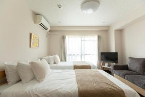 a hotel room with two beds and a television at Planetarium N in Yamashitachō