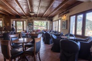 ein Restaurant mit Tischen, Stühlen und Fenstern in der Unterkunft Studio Merses in Mikro Chorio