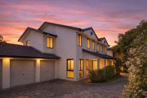 a house with a garage at sunset at Hawks Nest Hideaway | Spa, BBQ, Bikes & Pool Table in Hawks Nest