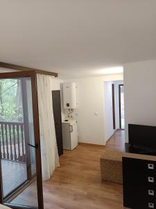 a living room with a television and a balcony at Casa Crina in Băile Herculane
