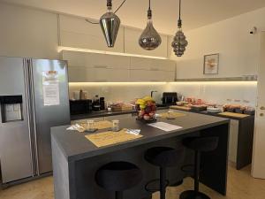 a kitchen with a island with bar stools at AirSisters Home in Ferno +28 photos