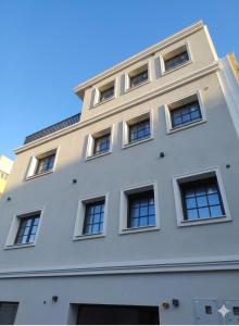 a white building with windows on the side of it at Strettorooms in Villa San Giovanni