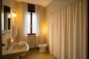 a bathroom with a sink and a toilet and a window at Villa 70 in Peschiera del Garda
