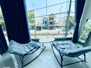 two chairs and a table in front of a window at Tie Homestay in Dong Hoi
