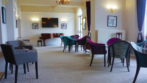 a waiting room with chairs and tables and a piano at Oban Hotel in Eastbourne +68 photos
