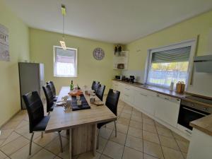 a kitchen with a wooden table and chairs in a room at Ferienhaus Ruth in Walow +16 photos