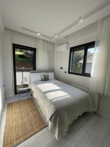 a bedroom with a large bed and two windows at Villa Gaia in Selçuk +30 photos